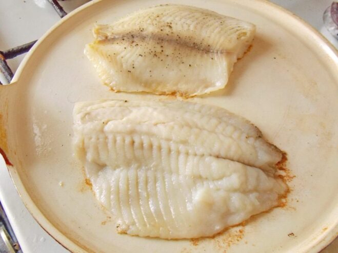 Flip the fish carefully once it's golden and opaque Flipping a golden-brown fish fillet in a hot pan with a spatula.