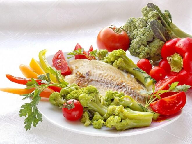A plate of perfectly fried ocean perch fillet served with a side of fresh vegetables.