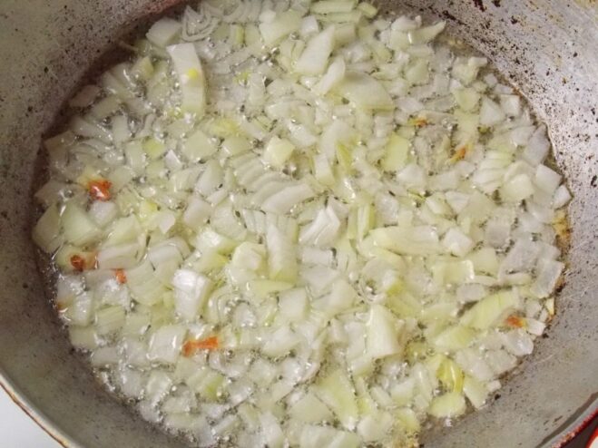 Starting the Savory Filling: Sautéing Onions Chopped onions being sautéed in a pan until translucent for the cabbage roll filling.