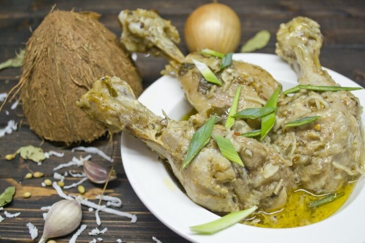 A bowl of ready-to-eat chicken and coconut curry, garnished with fresh herbs.