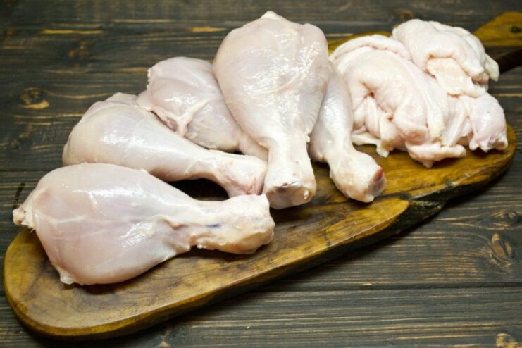 Prepping the Chicken: How to Remove the Skin for a Healthier Curry A hand removing the skin from a raw chicken leg in preparation for cooking.