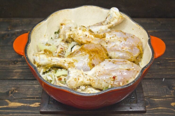Slow-Cooking to Perfection: Simmering the Curry for Maximum Flavor Marinated chicken legs being added to a pot with the curry base and cream, ready for slow cooking.