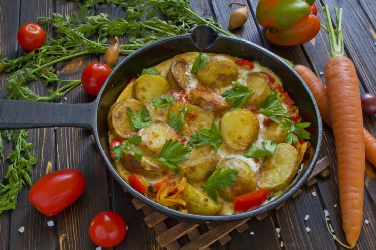 A whole Spanish potato tortilla in a frying pan, garnished with fresh parsley.