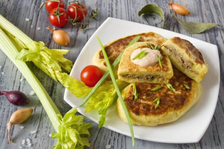 A plate of golden-brown potato zrazy, garnished with fresh herbs, ready to be served.