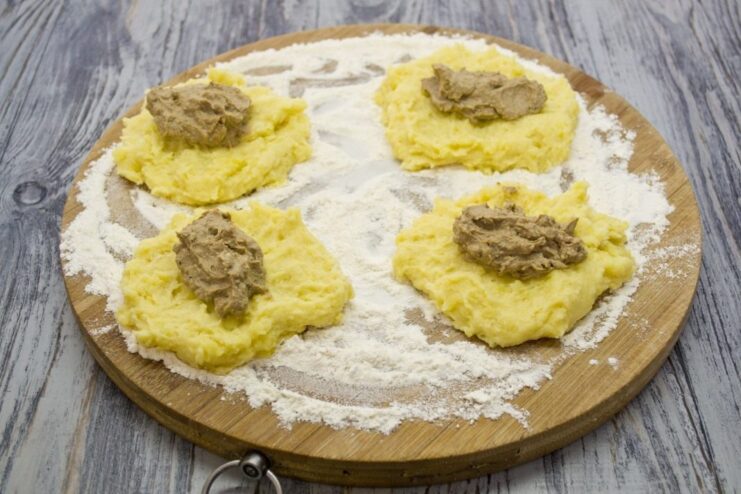 Assembling the Potato Zrazy with Liver Filling A flattened potato dough patty with a spoonful of chicken liver pâté in the center.