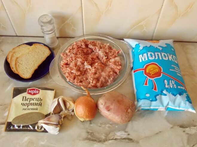 Ingredients for kotlety including ground meat, onion, potato, garlic, and bread on a wooden board.