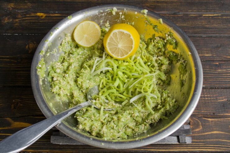 Adding Flavor with Leek and Lemon Juice Chopped leek and lemon juice being mixed into the broccoli patty batter.