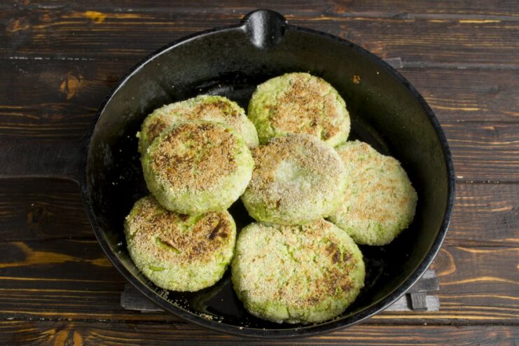 Frying Broccoli Patties to a Golden Brown Broccoli patties sizzling in a hot frying pan, turning golden brown.