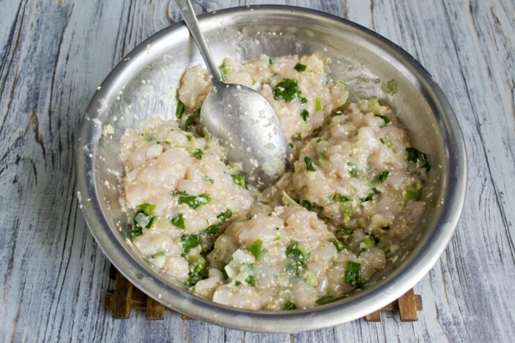 The finished chicken and spinach mixture being divided into four equal portions on a cutting board.