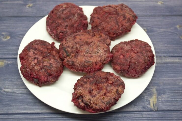 Beetroot patties being fried in a non-stick pan.