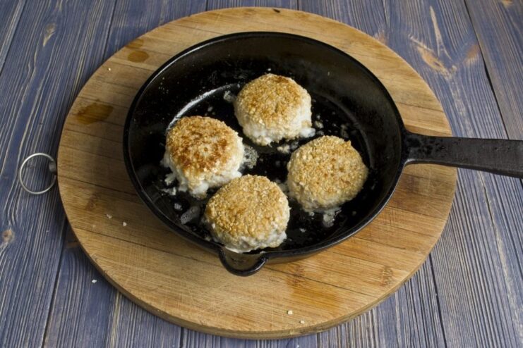 Pan-frying cod fish cakes until golden Cod fish cakes sizzling in a hot skillet, being fried to a golden-brown color.