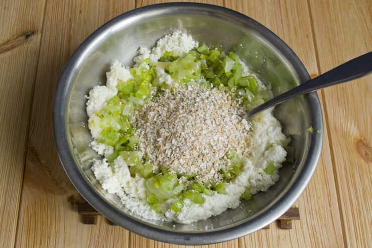 Adding oat bran to the mixture for binding and extra fiber. Oat bran being poured into the bowl with the farmer's cheese and vegetable mixture.