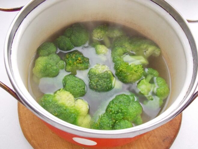 Blanching Broccoli Florets to Keep Them Vibrant Broccoli florets being added to a pot of boiling water to be blanched.