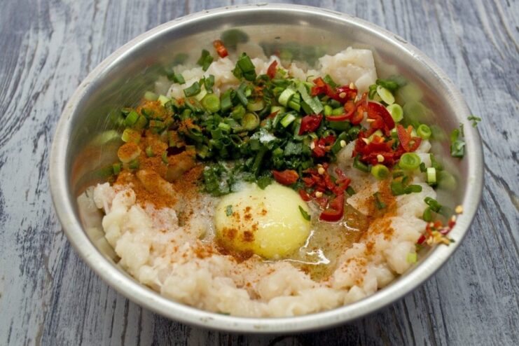 Seasoning the Chicken Mixture for a Flavor Boost Spices, including paprika, being added to the bowl with minced chicken.