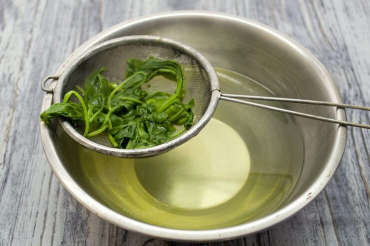 Blanching Spinach for the Cutlet Filling Fresh spinach leaves being blanched in a pot of boiling water.