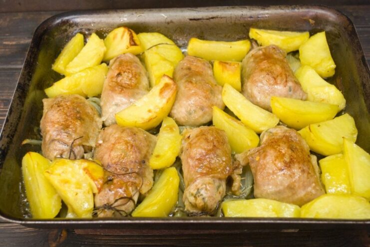 Chicken cutlets and potatoes roasting in the oven, turning golden-brown.
