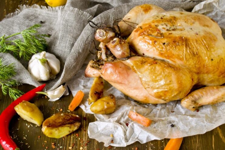 A beautiful whole roasted chicken, ready for carving. A whole roasted chicken with a golden-brown crust on a serving platter.