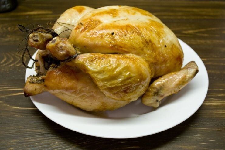 The finished whole roasted chicken, golden and delicious. A perfectly cooked whole roasted chicken with a crispy, golden-brown skin.