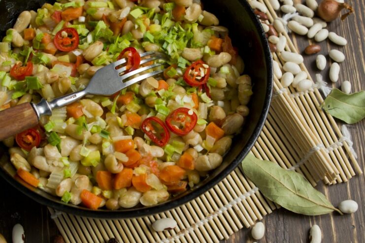 Hearty Vegetable and Bean Ragout Recipe - A delicious and simple one-pan meal. A bowl of ready-to-eat vegetable ragout with beans, garnished with fresh herbs.