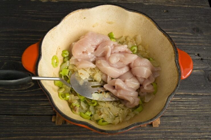 Searing the chicken strips to lock in the juices Strips of chicken fillet being sautéed in the Dutch oven.