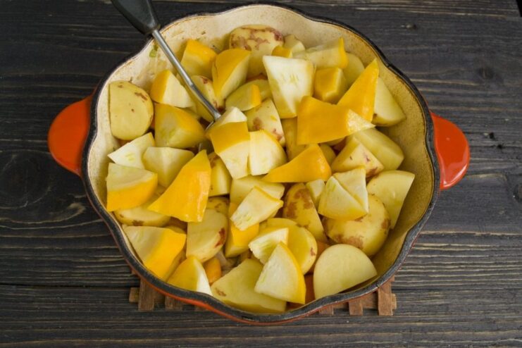 Adding fresh, tender pattypan squash to the stew Pieces of sliced pattypan squash are added to the pot with potatoes and carrots.
