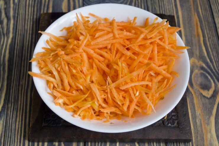 Step 1: Preparing the carrots for the vegetable ragout Freshly grated carrots in a bowl for the vegetable ragout recipe.