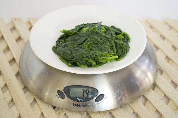 Step 2: Blanching the spinach to soften it and bring out its vibrant color. Blanching fresh spinach in a pot of boiling water.
