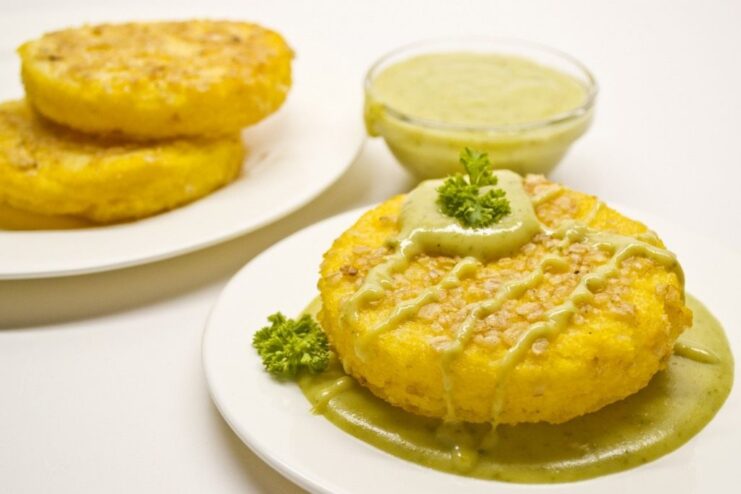 The Finished Dish: Polenta with Brussels Sprout Sauce Ready to Serve The final dish: golden polenta cakes served in a bowl with creamy green Brussels sprout sauce.