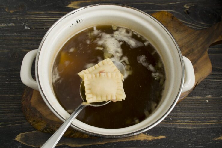 Cooking Ravioli in Broth for Extra Flavor Ravioli dumplings boiling in a pot of mushroom broth.