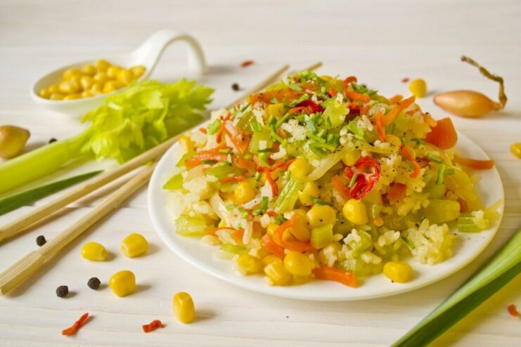 A bowl of finished Beijing-style rice with vegetables, garnished with herbs.