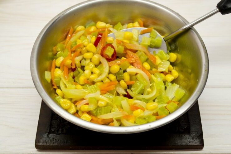 Stir-frying the vegetable mix until crisp-tender A mix of colorful vegetables being stir-fried in a pan.