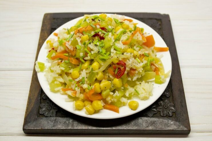 Finishing the dish with fresh herbs and spices Garnishing the Beijing-style rice with chopped green onions.