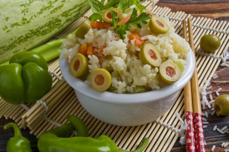 A delicious and easy one-pan meal: Jasmine rice with zucchini and olives. A plate of cooked jasmine rice with zucchini, olives, and fresh herbs.