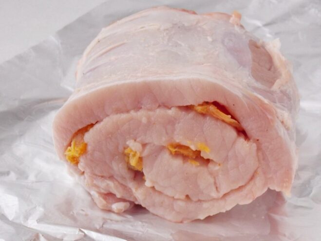 The Assembled Pork and Apricot Roll, Ready for Tying A neatly rolled raw pork loin filled with dried apricots, before being tied.