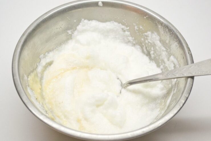 Whipping up a Light and Airy Batter for the Fish A bowl containing a smooth, light-colored batter being mixed with a whisk.