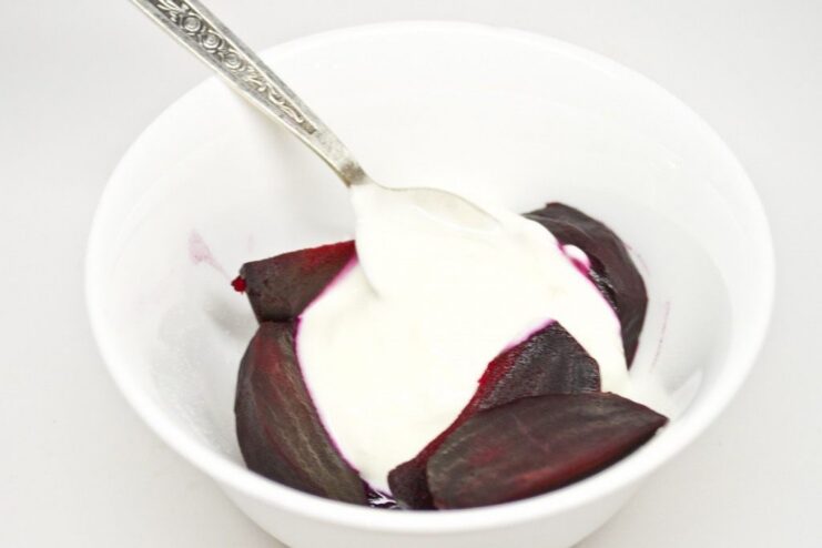 Combining Ingredients for the Beetroot Purée A bowl with cooked, sliced beetroot and a dollop of white Greek yogurt, ready to be blended.