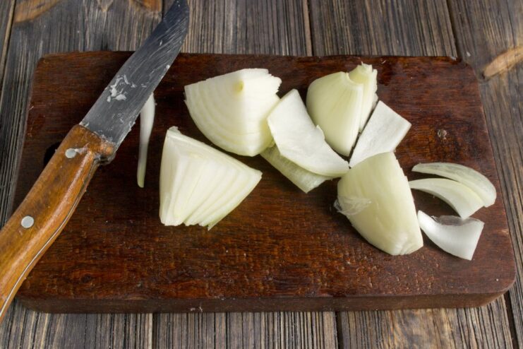Finely Diced Onion for Maximum Flavor in Fish Cakes A pile of finely diced yellow onion on a cutting board.