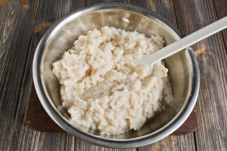 Using a Food Processor to Make a Smooth Fish Cake Mixture A food processor bowl containing minced pollock, onion, and bread.