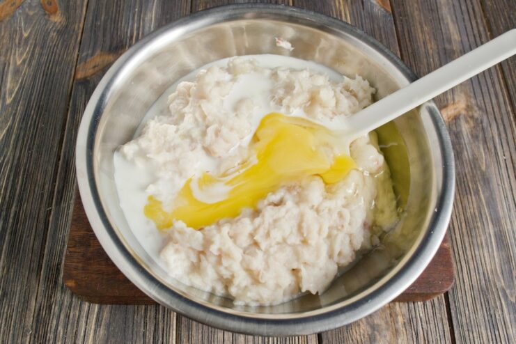 Enriching the Fish Cakes with Cream and Spices for Juiciness Pouring cream into the bowl with the fish cake mixture.