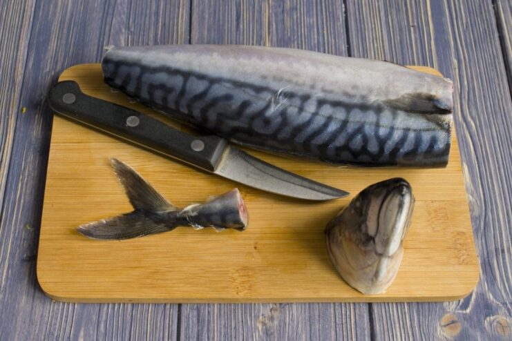 Step-by-Step Guide to Cleaning and Prepping Mackerel A whole mackerel being cleaned and prepared for cooking on a cutting board.