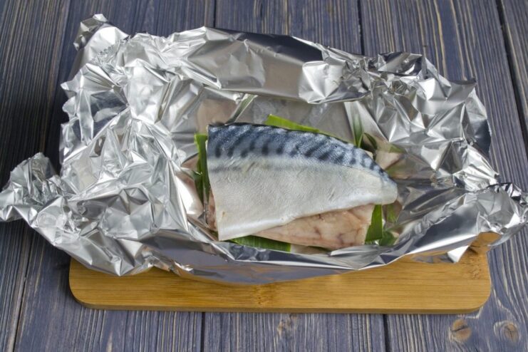 Preparing Mackerel for Steaming on a Leek Bed Mackerel fillets placed on a piece of leek on aluminum foil.