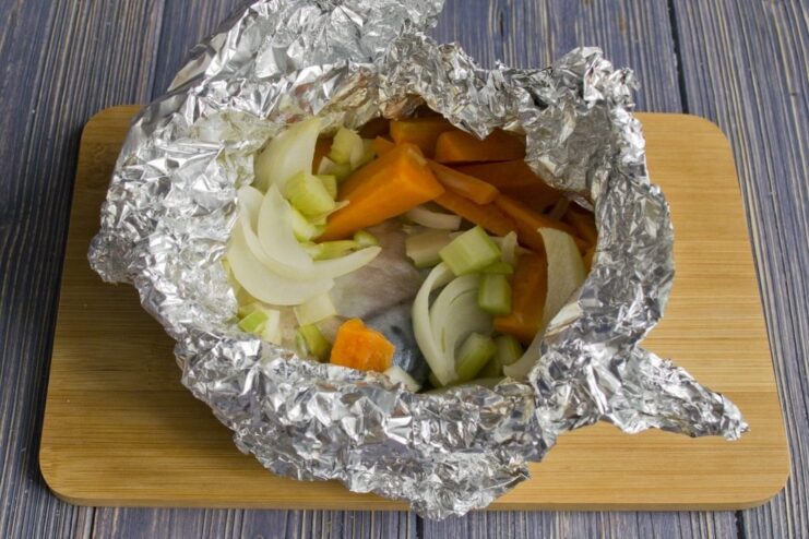 Steaming Mackerel in a Foil Packet over a Pot A foil packet with mackerel steaming in a colander over a pot of boiling water.