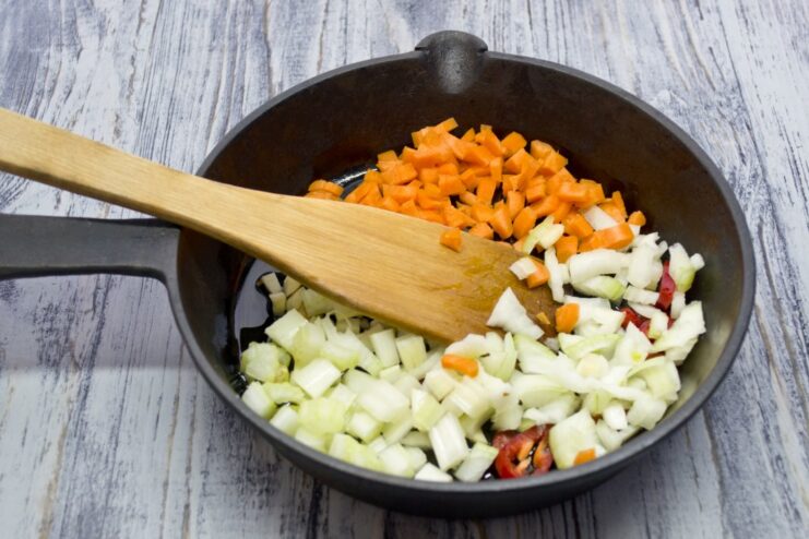 Building the Flavor Base with a Classic Mirepoix Diced onion, carrots, and celery being sautéed in a pan.