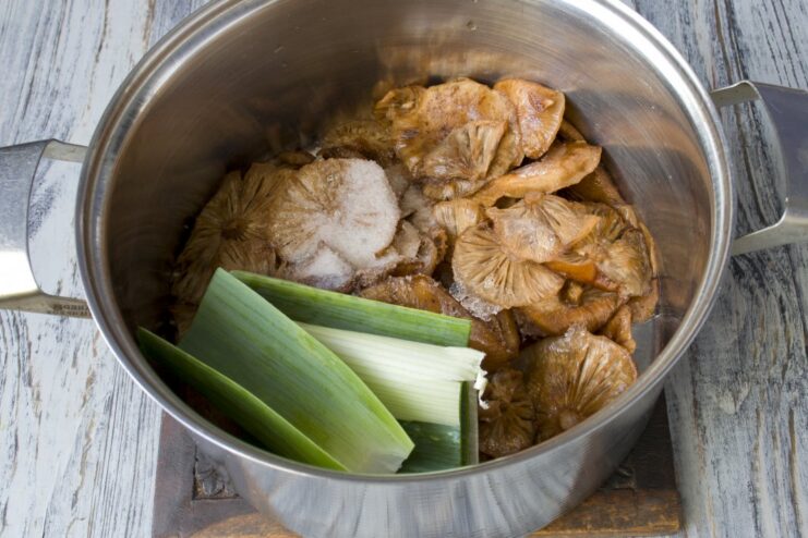 First step: boiling frozen opyata mushrooms until tender Frozen opyata mushrooms boiling in a pot of water with spices.
