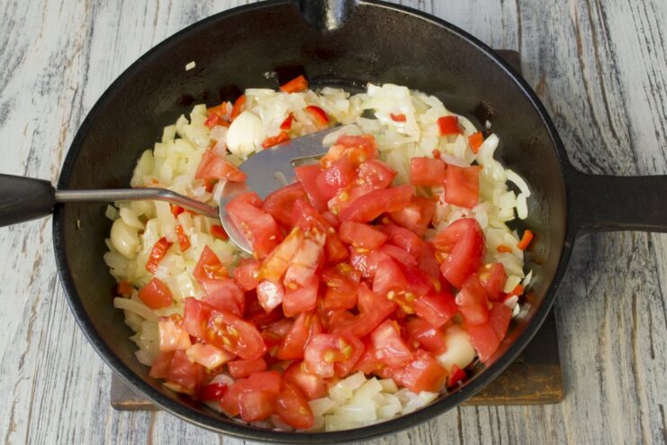 Preparing the tomatoes for the mushroom sauce Finely chopped peeled tomatoes being added to the pan.
