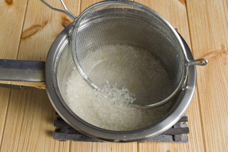 Preparing Perfect Sushi Rice: Soaking and Cooking Steps A pot with short-grain rice and water, ready for cooking sushi rice.