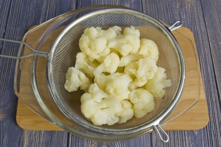 Step-by-Step: Blanching Cauliflower Florets White cauliflower florets being blanched in a pot of boiling water.