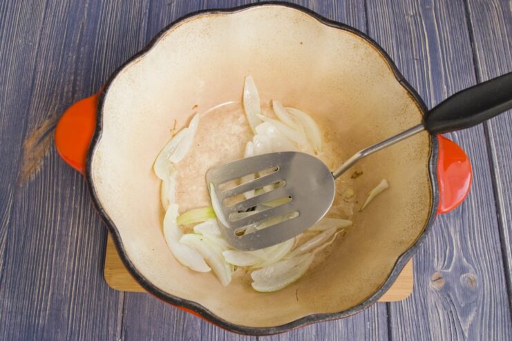 Sautéing Onions Until Translucent - The Flavor Base Chopped onions being sautéed in a pan until soft and translucent.