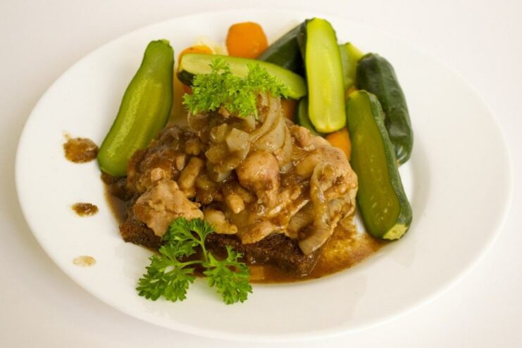 The final dish: tender chicken in beer served with steamed vegetables. A serving of chicken in beer on a plate with steamed vegetables on the side.