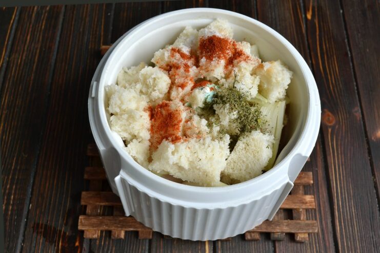 Blender bowl with chicken, onion, egg, and now adding milk-soaked bread, paprika, and dried dill.